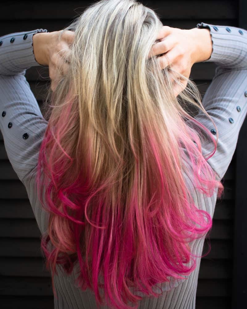 a woman with a pink dip dye hair color