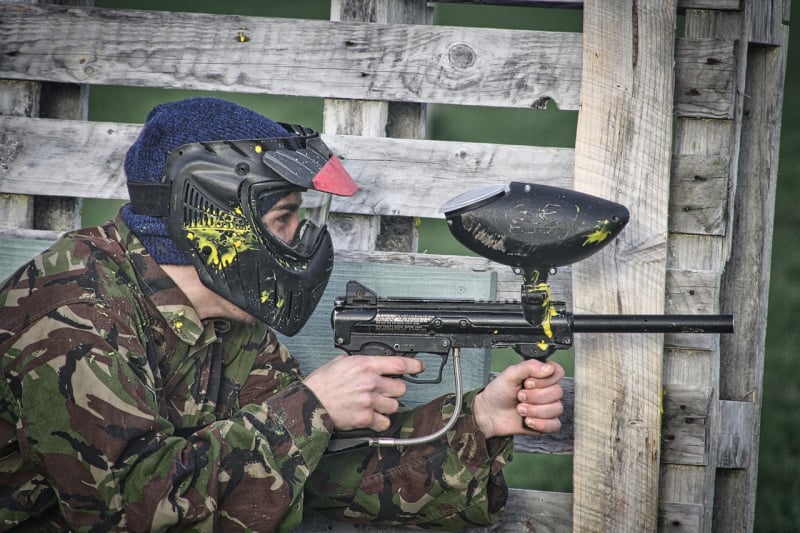 a person wearing paintball gear and holding a paintball gun