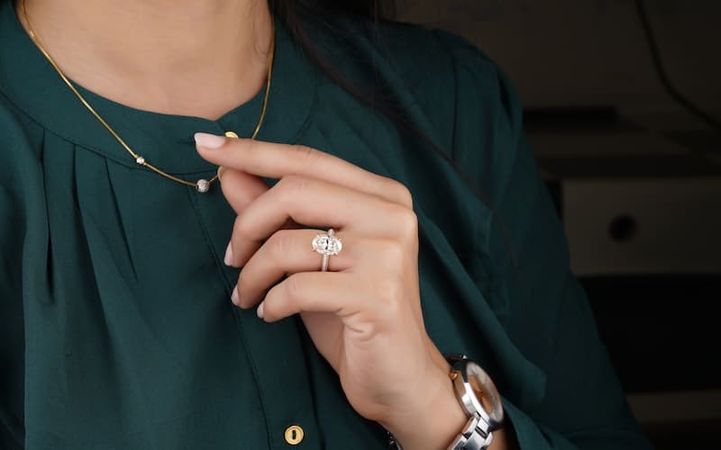 a woman wearing a dark green shirt and cz jewelry