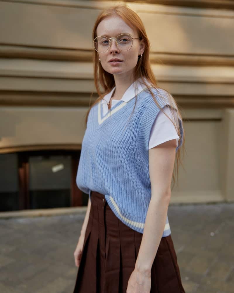 woman wearing a tennis skirt and sweater vest