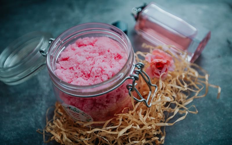 pink body scrub in a glass jar