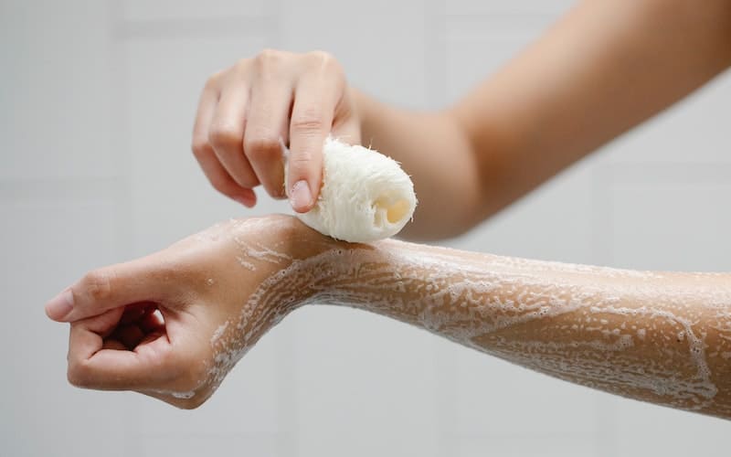 a woman washing with a loofah