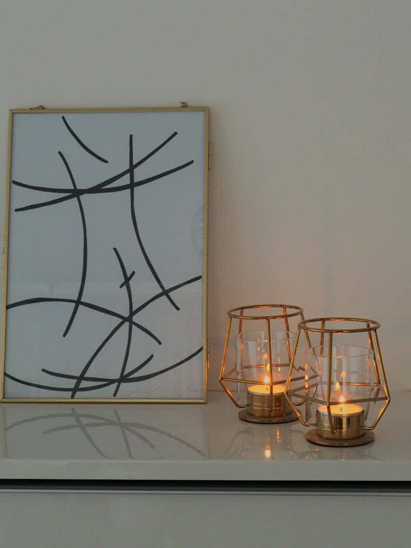 candle holders on a white table with a modern photo