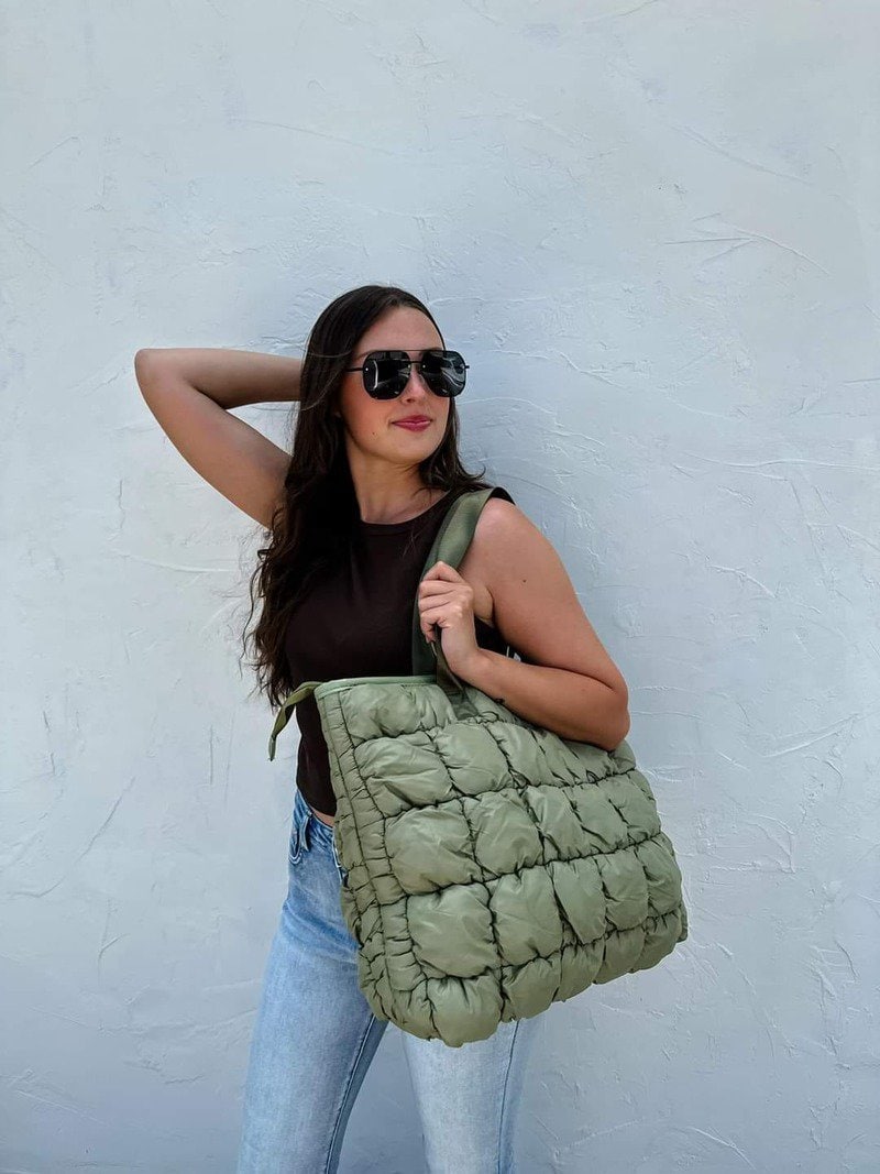 woman holding a green tote bag