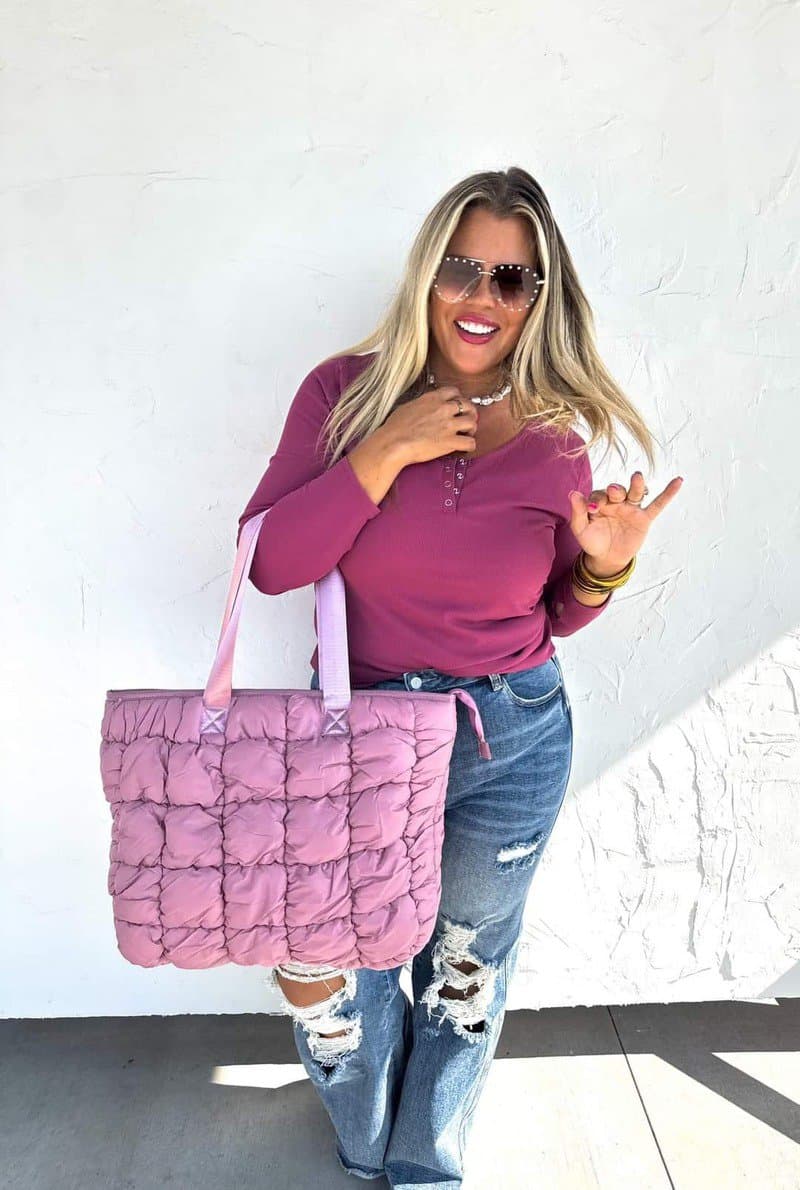 Woman showing off the pink puffer bag trend