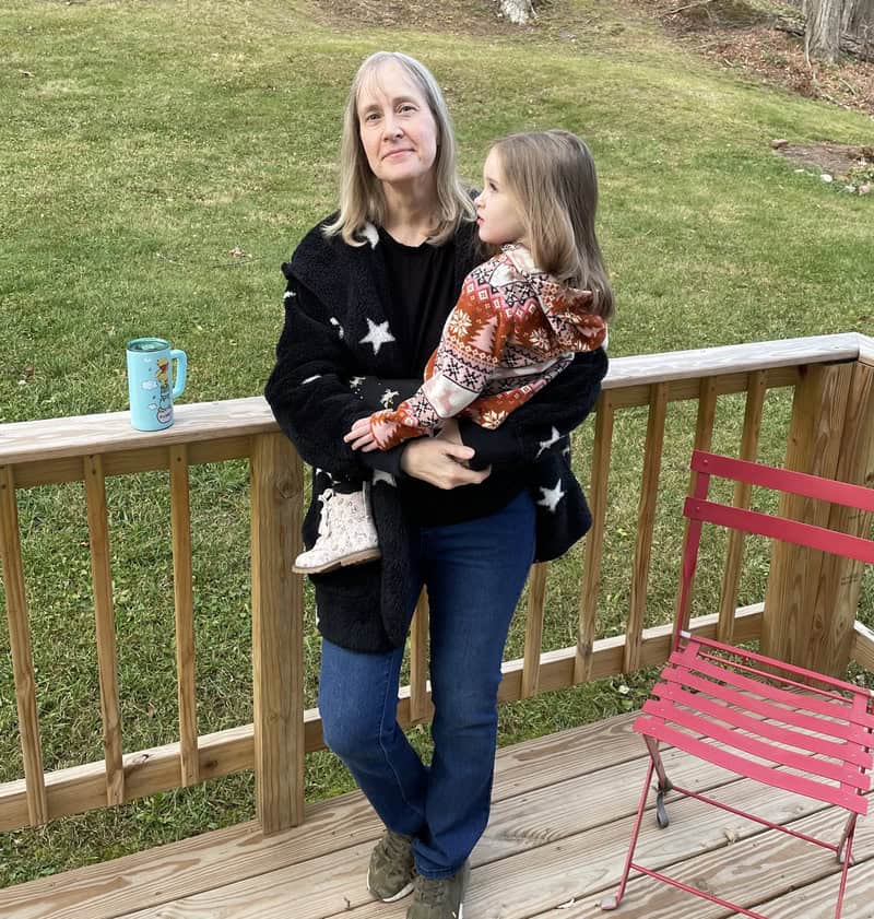 woman wearing Blue Faithful jeans holding a child