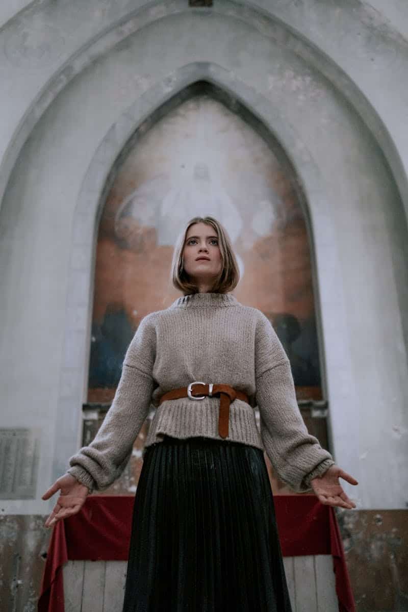 woman wearing a sweater and skirt with a belt