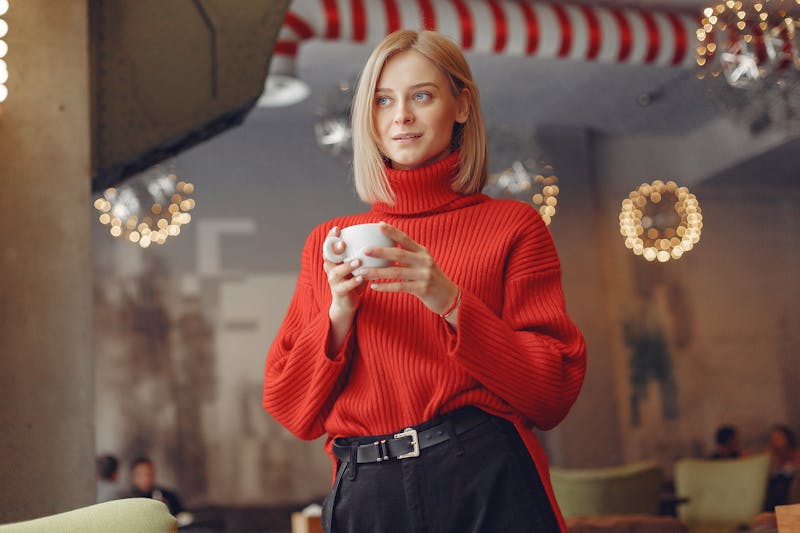 woman smiling holding a cup of coffee