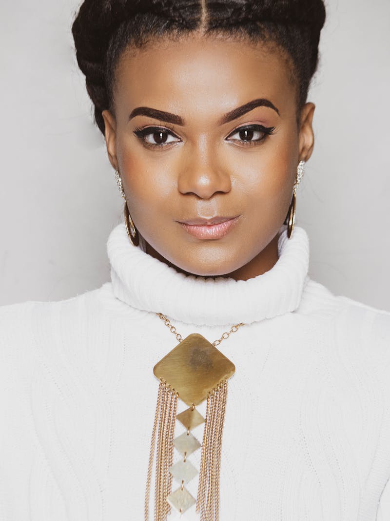 woman wearing a gold statement necklace and white shirt