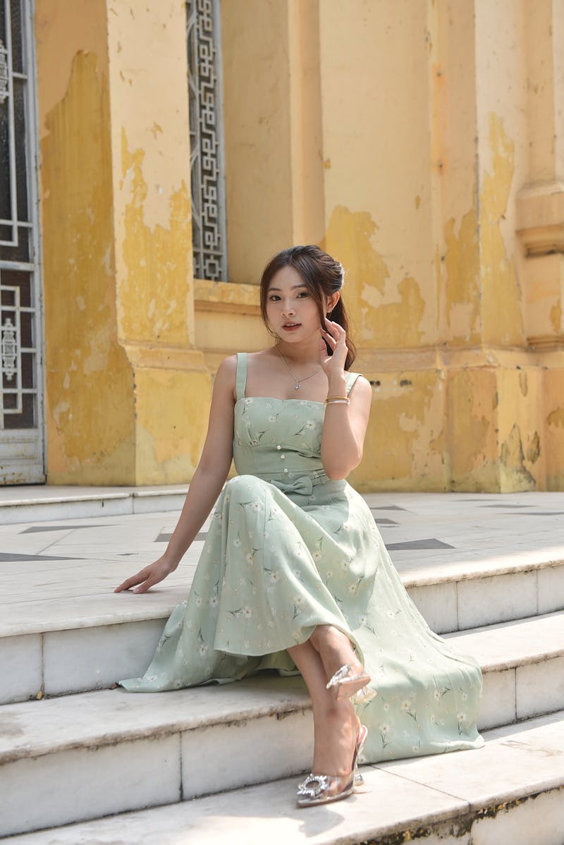 woman wearing a pastel green dress sitting on the stairs