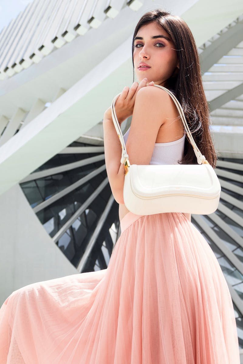 woman holding a handbag wearing a pink dress