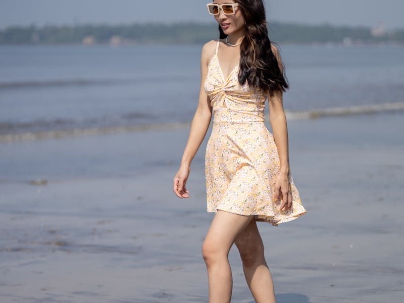 woman in a short dress walking on the beach