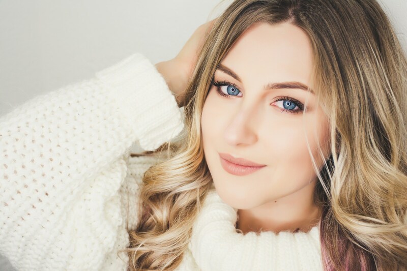 woman with blonde highlights wearing white sweater